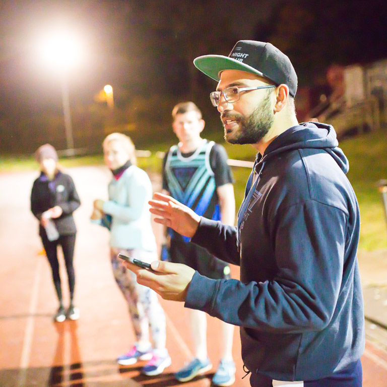 Running coach Arj speaking to Friday Night Track Club