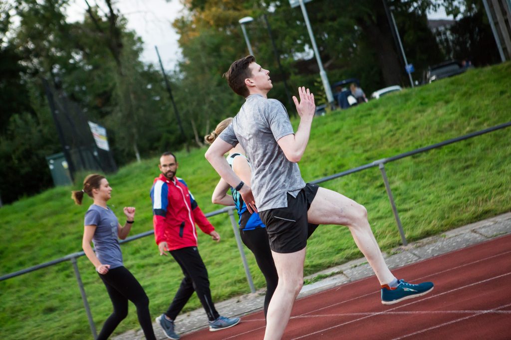 Running Coach Arj coaching runners on a track drills